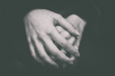 Close-up of human hand against black background