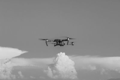 Low angle view of drone flying against sky