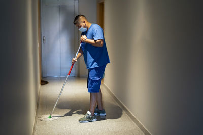 Cleaning staff disinfecting the floor with the mop to avoid covid19