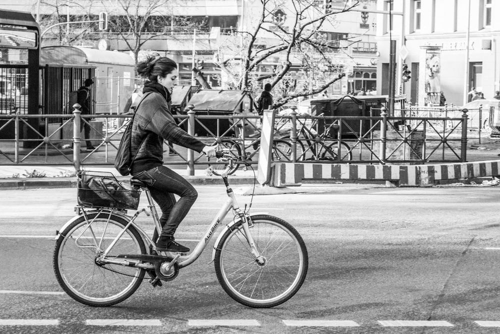 bicycle, mode of transport, transportation, land vehicle, building exterior, lifestyles, men, architecture, street, built structure, full length, leisure activity, city, riding, side view, city life, stationary, casual clothing