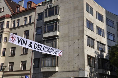 Low angle view of road sign by building