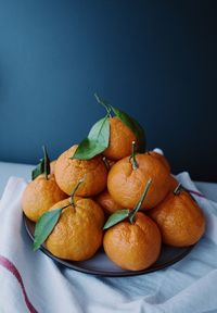 High angle close-up of oranges in plate on table