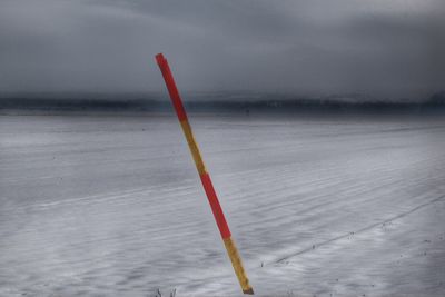 Close-up of snow on shore against sky