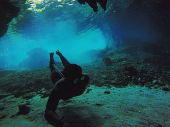 People on rock formation in sea