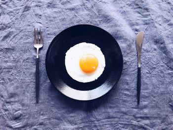 Directly above shot of fried egg in plate on table