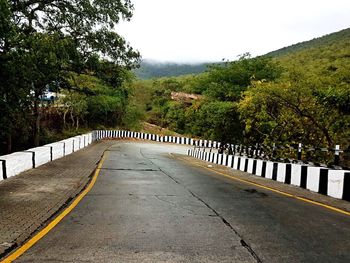 Road amidst trees against sky