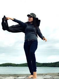 Beautiful young woman standing on pier 