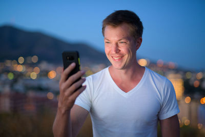 Portrait of smiling man using mobile phone
