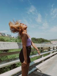 Full length of woman standing against sky