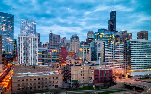 Illuminated buildings in city against sky