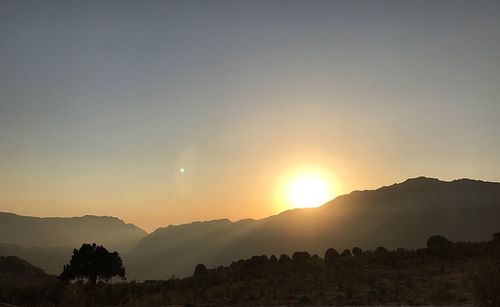 Scenic view of silhouette mountains against clear sky during sunset