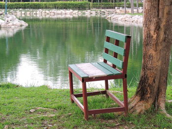 Empty bench by lake in park