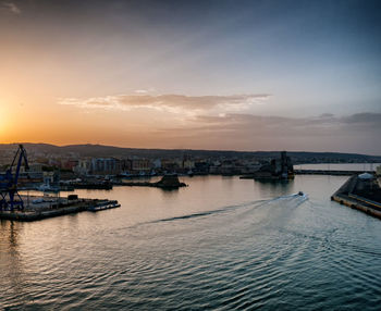 View of city at waterfront during sunset