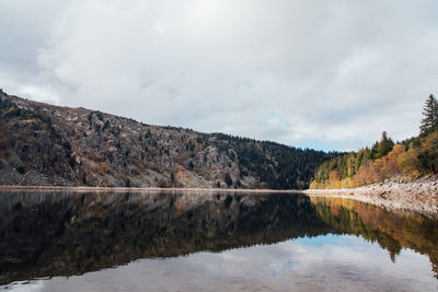 Scenic view of lake by mountain against sky