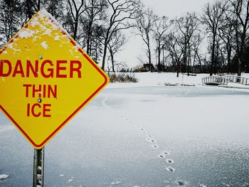 Road sign against sky during winter