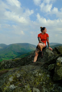 Full length of man sitting on rock