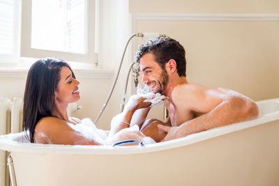 Side view of shirtless man in bathroom at home