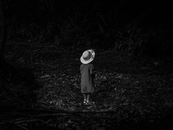 Rear view of girl standing in forest