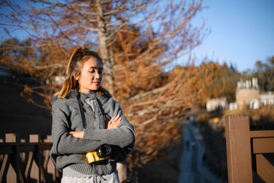 Full length of woman standing in park during autumn