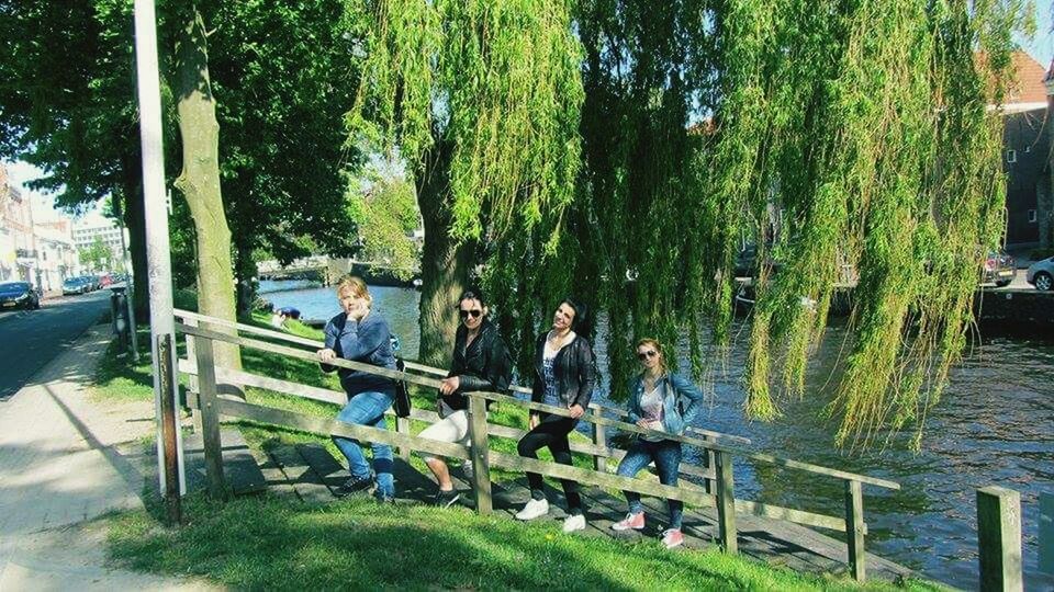 tree, lifestyles, men, person, leisure activity, water, togetherness, sitting, large group of people, rear view, transportation, medium group of people, green color, sunlight, walking, day, mode of transport, casual clothing