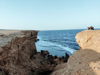 Rock formation on beach against clear sky