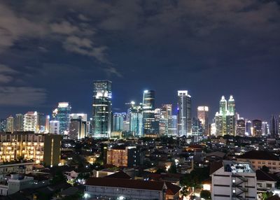 High angle view of illuminated buildings against sky at night