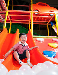 Happy boy playing on slide