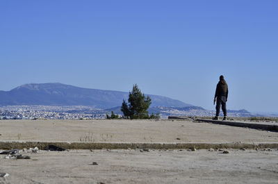 Man standing clear blue sky