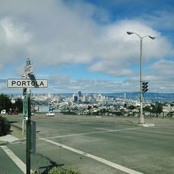 Road sign against cloudy sky