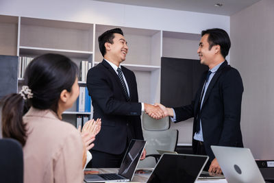 Business colleague shaking hands in office