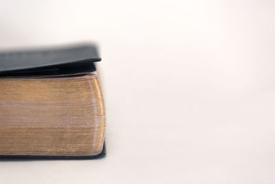 Close-up of open book on table against white background