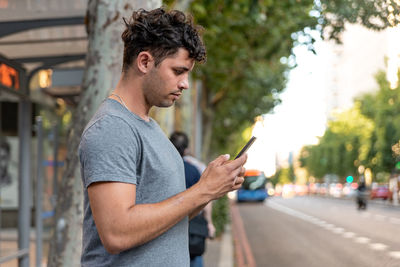 Young latin man in the city using the mobile phone.