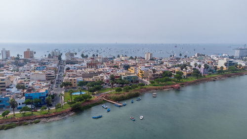 High angle view of townscape by sea against sky