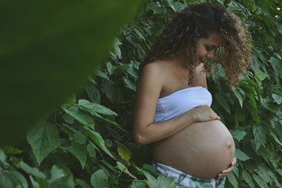 Pregnant woman standing by plants