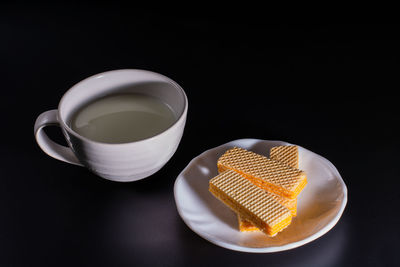 Close-up of coffee served on table against black background