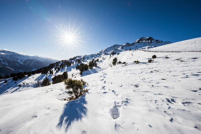 Scenic view of snow covered mountains against blue sky