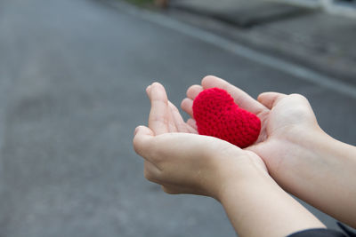Close-up of hands holding red heart
