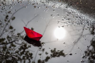 High angle view of wet glass floating on water