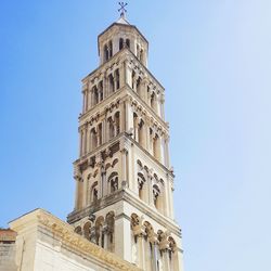 Low angle view of bell tower against blue sky