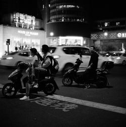 People riding motorcycle on road at night