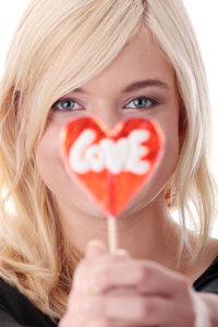 Close-up portrait of woman holding heart shape