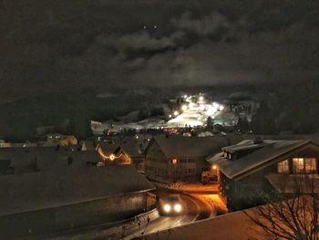 Illuminated city against sky at night