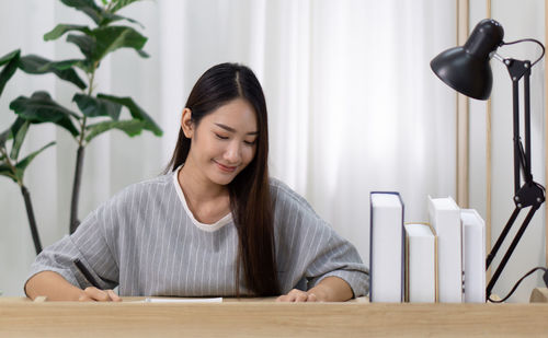 Portrait of young woman sitting on table