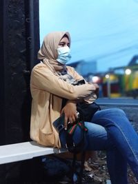 Full length of woman sitting on seat