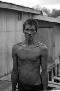 Portrait of shirtless man standing outdoors