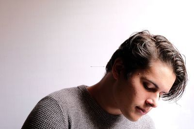 Thoughtful young man looking away against white background