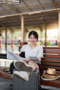 Portrait of young woman sitting at railroad station