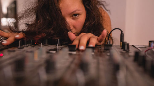 Close-up of fashionable young woman playing music at home