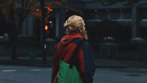 Rear view of woman standing on street in city