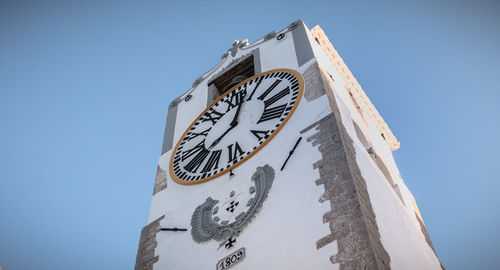 Low angle view of clock tower against clear sky